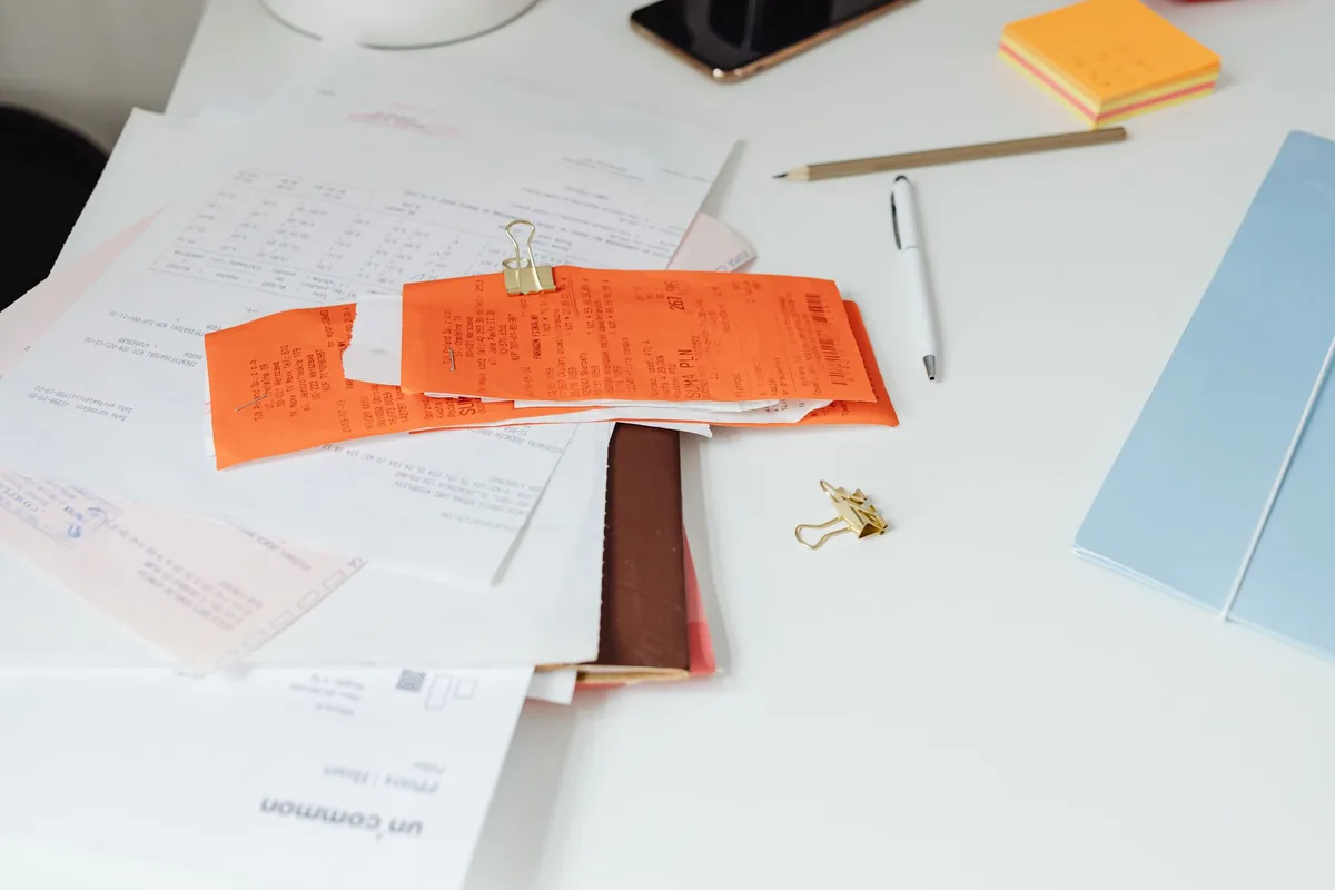 Bureau avec des factures et documents comptables posés sur un bureau de travail