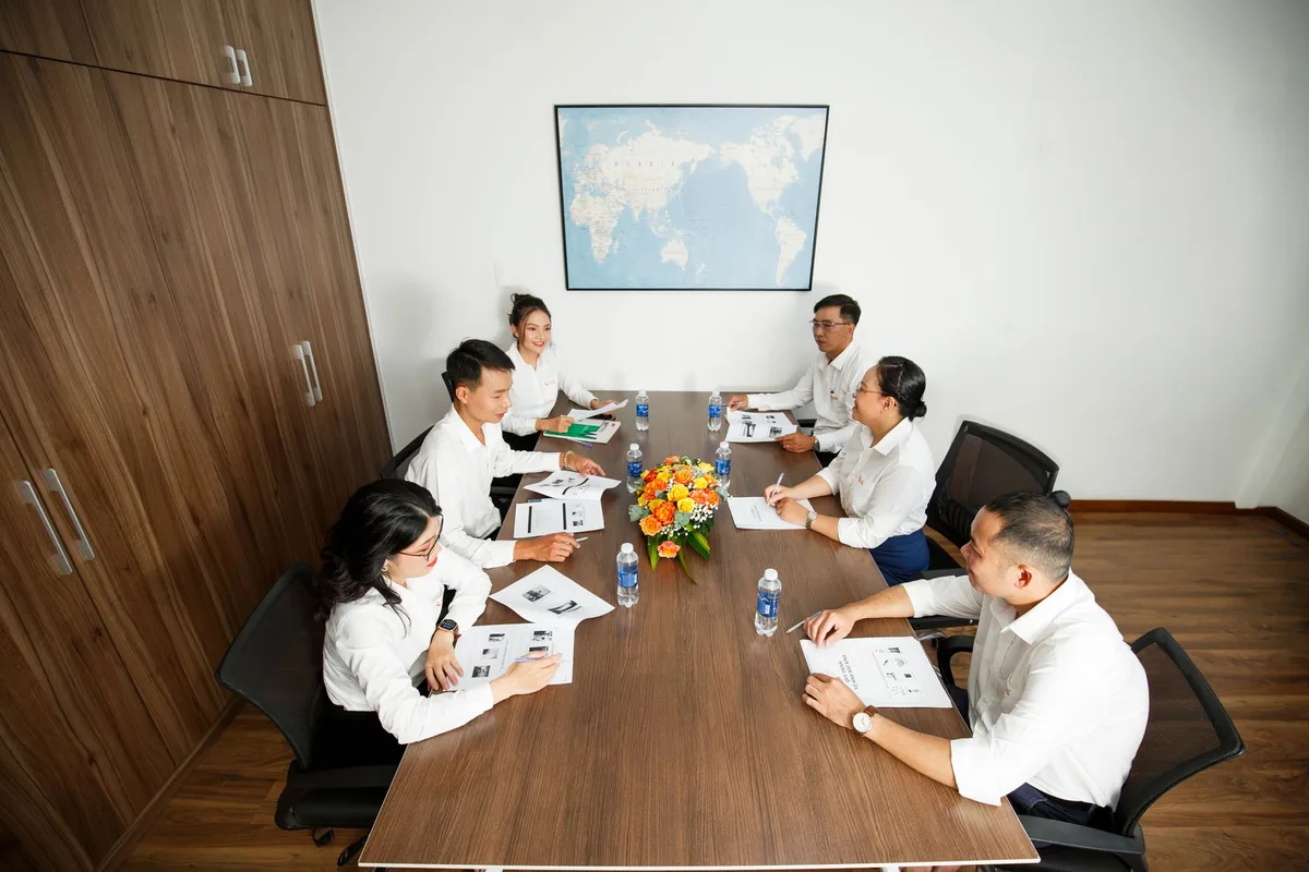 Table de salle de réunion avec documents, agenda et participants en réunion d'affaires