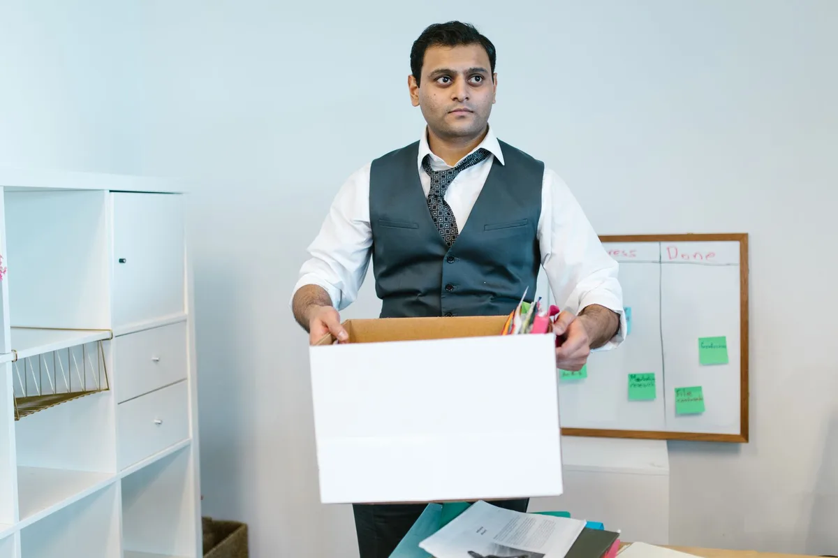 Salariée consultant un document contractuel devant son ordinateur portable au bureau