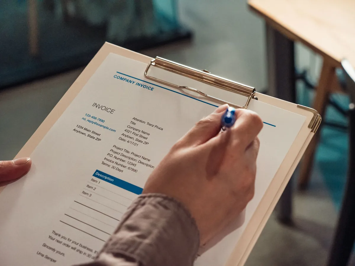 Dirigeant préparant une facture d'acompte sur son ordinateur avec une calculatrice