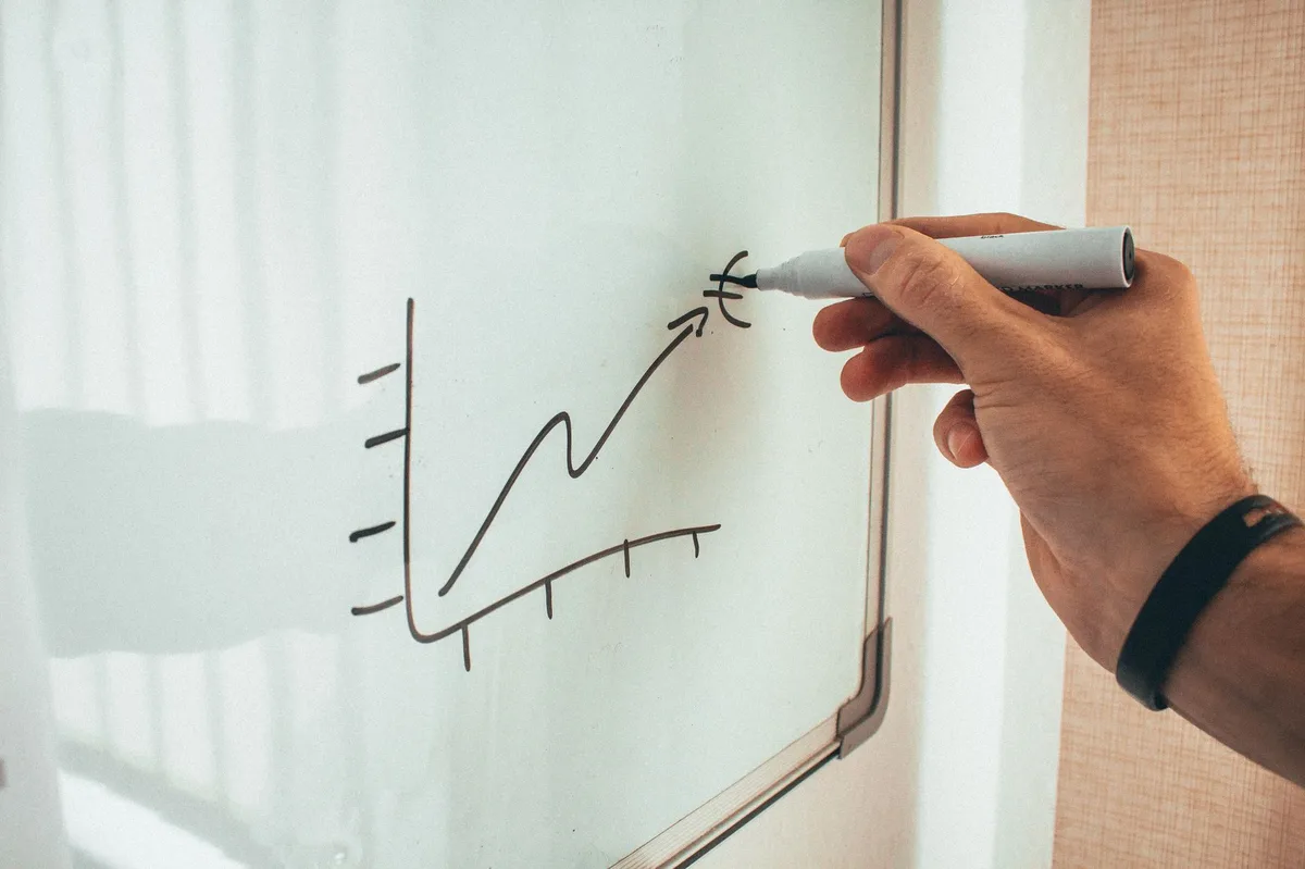 Dirigeante réfléchissant à sa stratégie de croissance devant un tableau à quatre cases