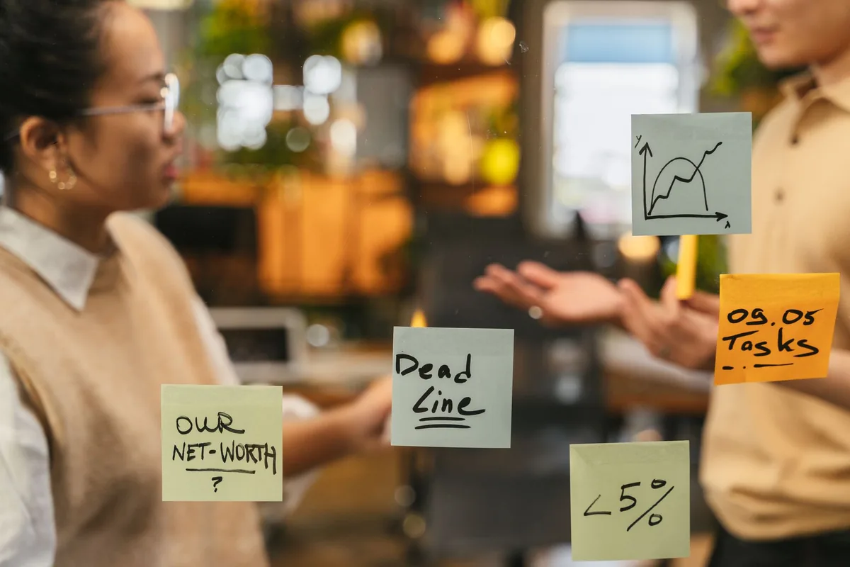 Équipe en atelier de résolution de problème avec post-its sur tableau mural