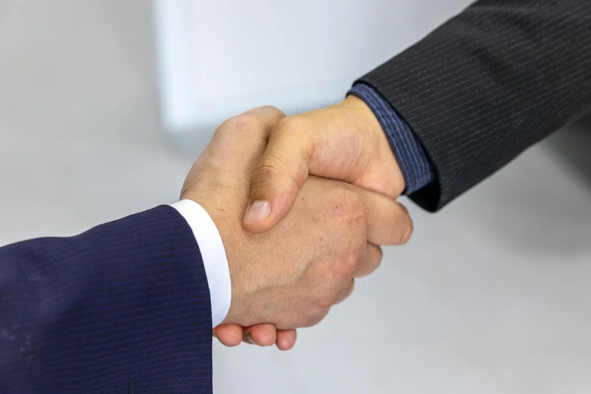 Poignée de main entre deux chefs d'entreprise lors d'une cession-reprise