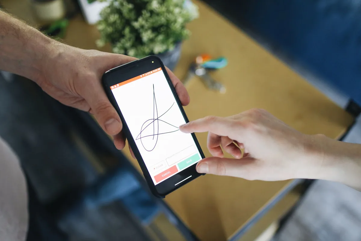Signature électronique sur tablette avec stylet dans un contexte professionnel