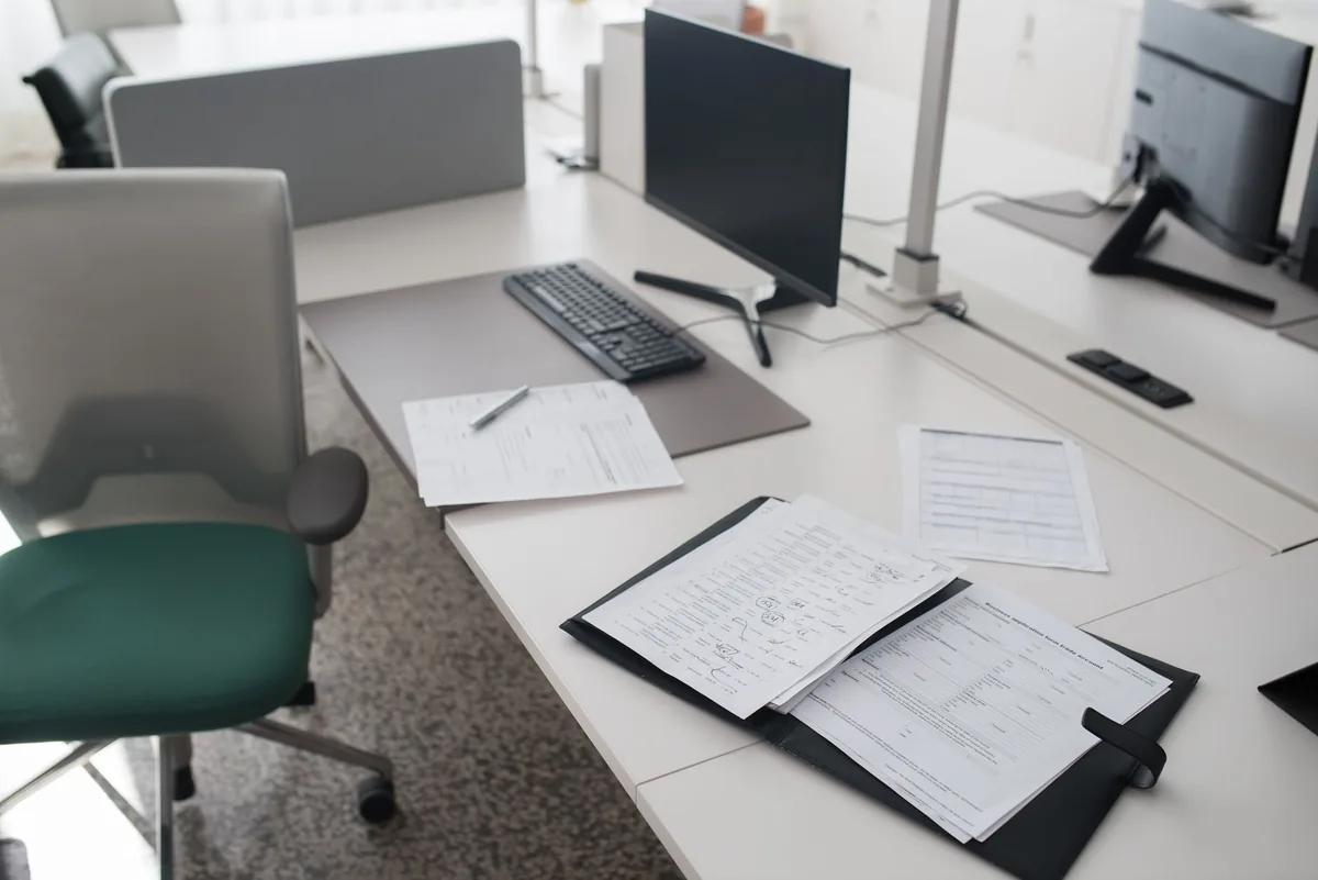 Documents de fin de contrat et calculatrice posés sur un bureau