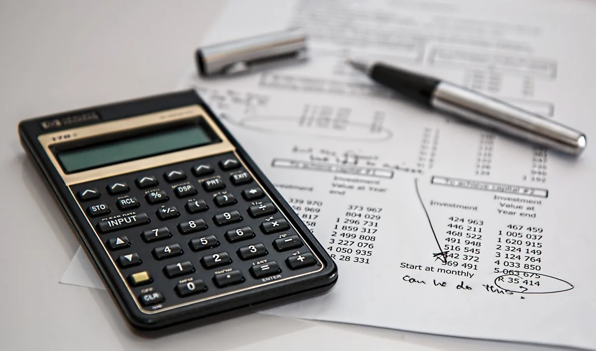 Calculatrice et graphiques de rentabilité sur un bureau, pour illustrer le calcul du taux de marge et du taux de marque